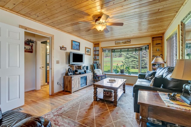living area featuring wooden ceiling, baseboards, wood finished floors, ceiling fan, and ornamental molding