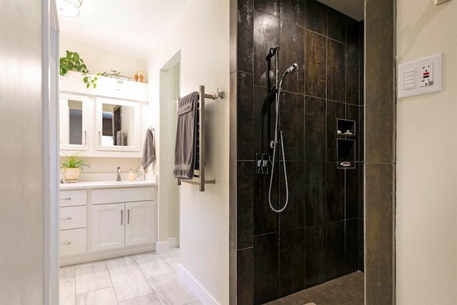 bathroom with a walk in shower, baseboards, and vanity