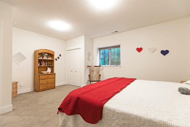 bedroom with baseboards, a closet, visible vents, and light colored carpet