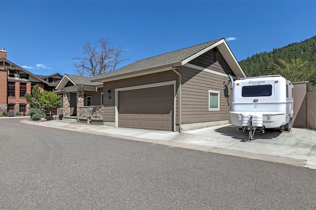ranch-style home with roof with shingles and a garage