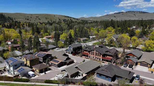 drone / aerial view featuring a view of trees, a mountain view, and a residential view