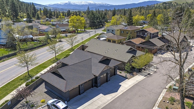 drone / aerial view with a mountain view, a wooded view, and a residential view