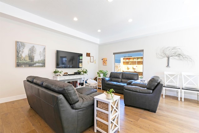 living room featuring light wood-type flooring, baseboards, and recessed lighting