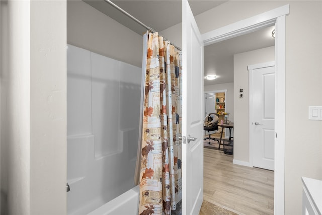 bathroom with shower / tub combo and wood finished floors
