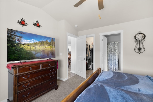 bedroom featuring baseboards, ensuite bathroom, vaulted ceiling, a spacious closet, and carpet floors