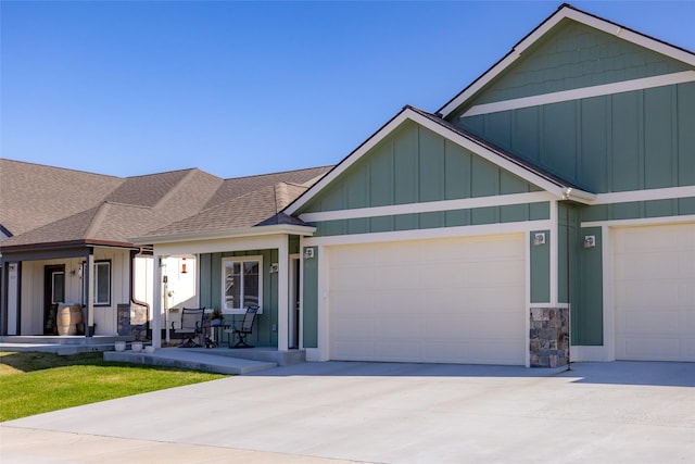 craftsman-style house featuring roof with shingles, concrete driveway, a garage, and board and batten siding