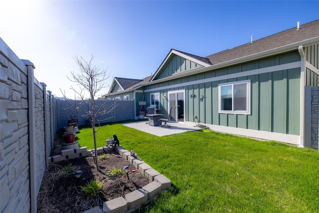 back of house with a lawn, board and batten siding, a patio, roof with shingles, and a fenced backyard