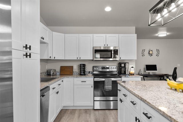 kitchen with white cabinets, recessed lighting, appliances with stainless steel finishes, and light wood-style floors