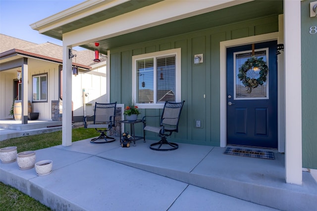 entrance to property with board and batten siding and a porch