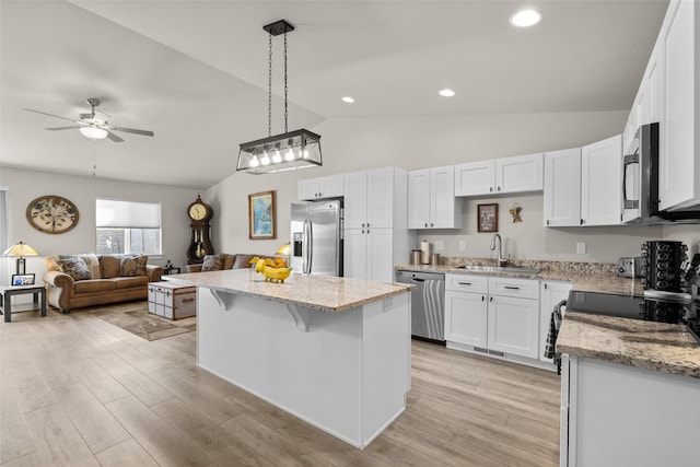 kitchen featuring white cabinets, appliances with stainless steel finishes, a ceiling fan, and a sink
