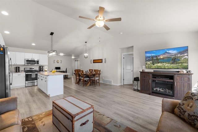 living area with light wood-type flooring, visible vents, recessed lighting, a ceiling fan, and baseboards