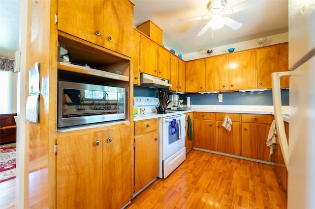 4420 7th Ave S, Great Falls, MT 59405 - kitchen featuring stainless steel microwave, light wood-type flooring, under cabinet range hood, light countertops, and white range with electric cooktop