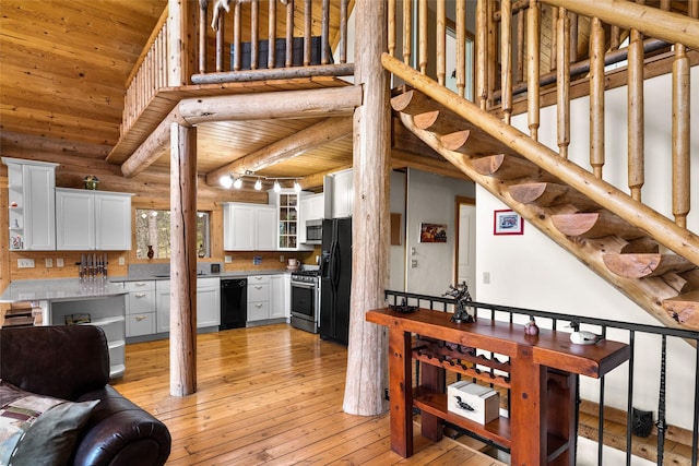 148 Muley Rd, Lakeside, MT 59922 - kitchen featuring light wood-style flooring, wooden ceiling, white cabinetry, a towering ceiling, and black appliances