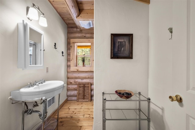 148 Muley Rd, Lakeside, MT 59922 - bathroom featuring wooden ceiling, wood-type flooring, beamed ceiling, and rustic walls