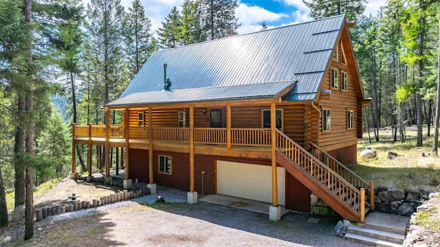 148 Muley Rd, Lakeside, MT 59922 - view of front of house featuring driveway, log siding, metal roof, an attached garage, and stairs