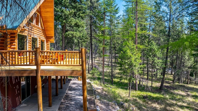 148 Muley Rd, Lakeside, MT 59922 - deck featuring a wooded view and a carport