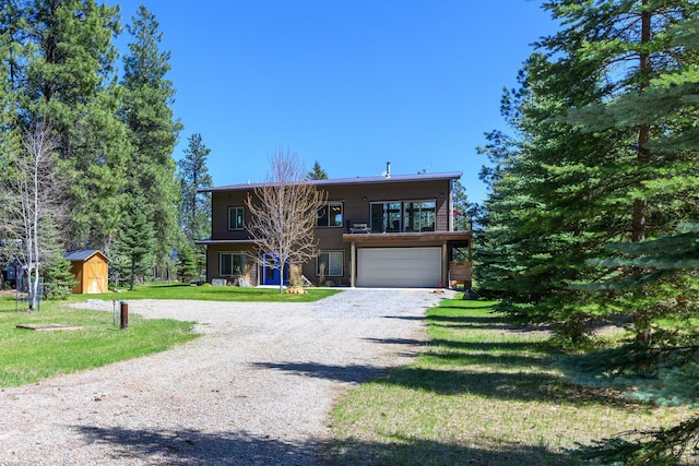 282 Mountain View Rd, Rexford, MT 59930 - view of front of home featuring gravel driveway, an attached garage, a storage shed, a front lawn, and a balcony