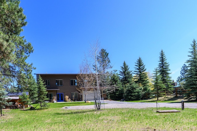 view of front of house featuring a front lawn and gravel driveway