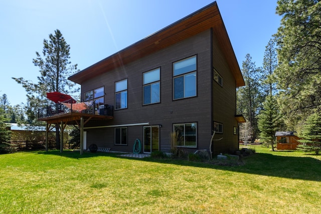 rear view of house featuring a deck and a lawn