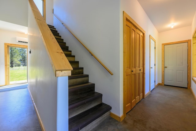 staircase featuring concrete floors, baseboards, and an AC wall unit