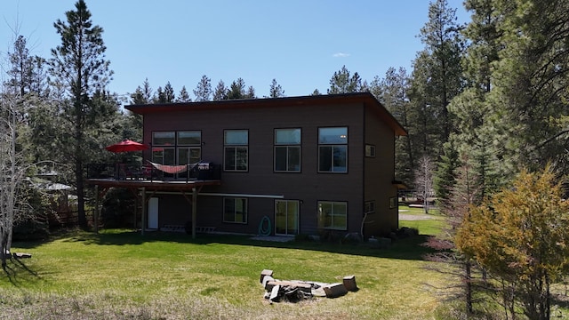 back of property featuring a yard and a deck