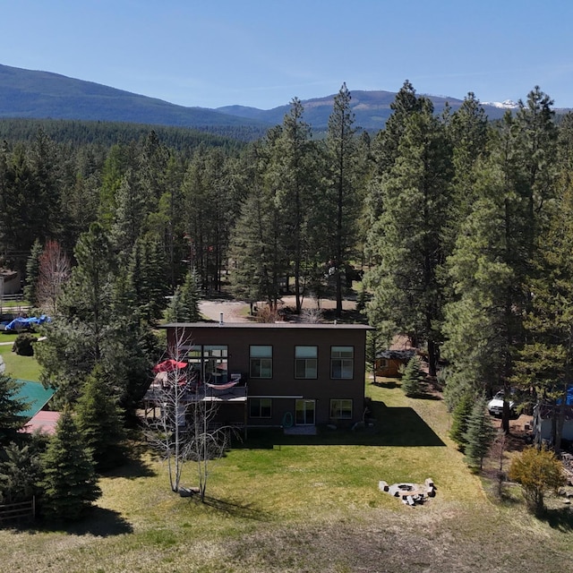 exterior space with a yard, a wooded view, and a mountain view