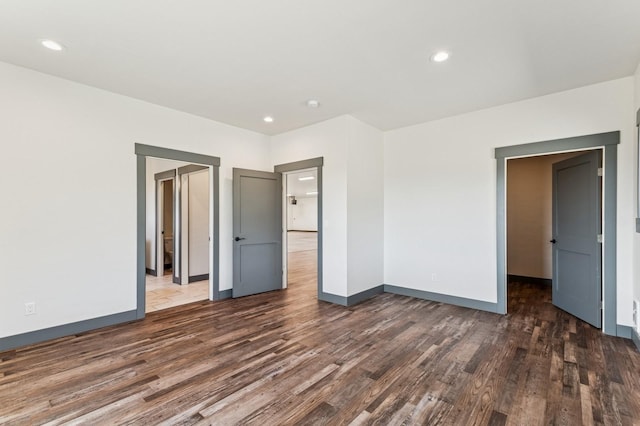 unfurnished bedroom featuring wood finished floors, baseboards, and recessed lighting