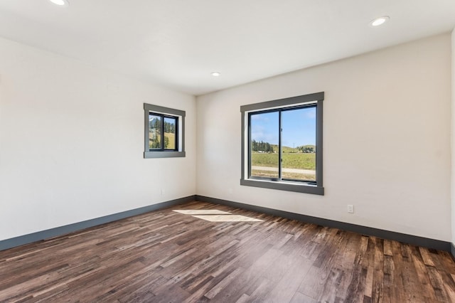 unfurnished room featuring recessed lighting, baseboards, and dark wood finished floors