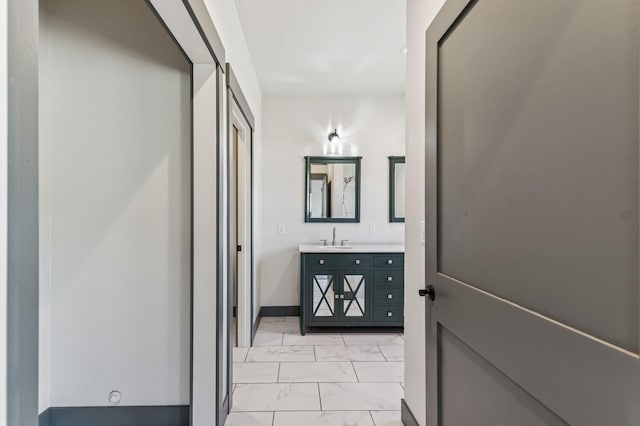 bathroom with baseboards, marble finish floor, and vanity