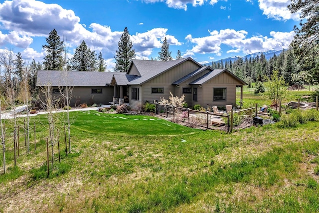 rear view of house featuring a yard, a mountain view, and board and batten siding