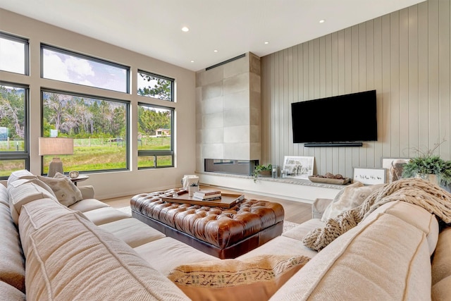 living area with a healthy amount of sunlight, a fireplace, recessed lighting, and wood finished floors