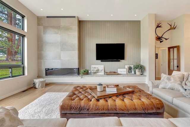 living area featuring baseboards, recessed lighting, plenty of natural light, and wood finished floors