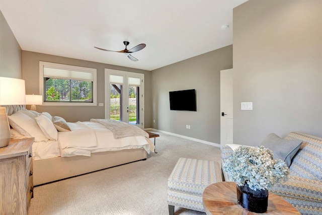 bedroom featuring light colored carpet, a ceiling fan, baseboards, and access to exterior