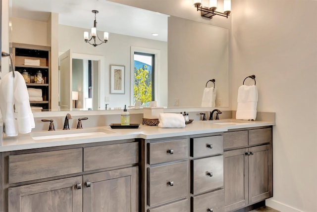 full bathroom with a sink, an inviting chandelier, and double vanity