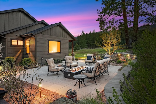 patio terrace at dusk featuring an outdoor living space with a fire pit