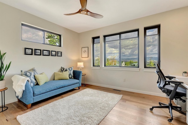 office area featuring ceiling fan, baseboards, visible vents, and wood finished floors