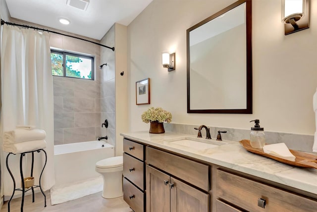 full bath with toilet, visible vents, vanity, and shower / tub combo with curtain