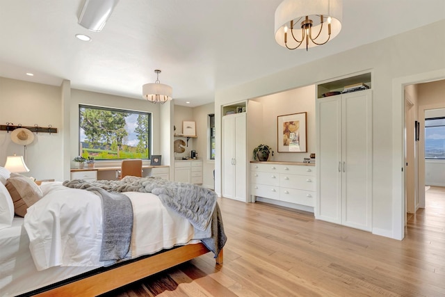 bedroom with light wood-style floors, a chandelier, and recessed lighting