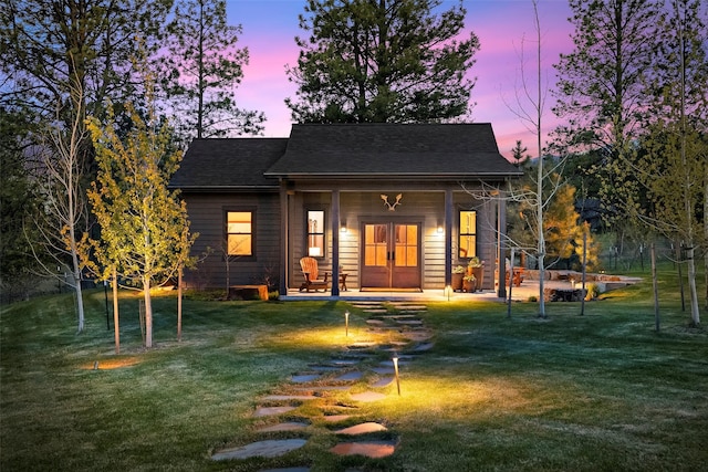 back of house featuring a yard and french doors