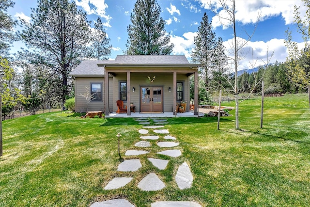 back of property with a yard, french doors, and a porch