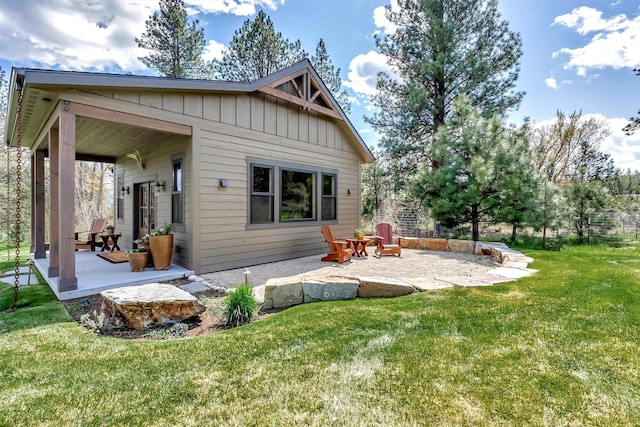 rear view of house featuring a yard, board and batten siding, and a patio area