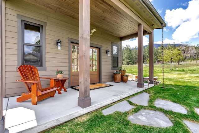 view of patio featuring a porch and a mountain view