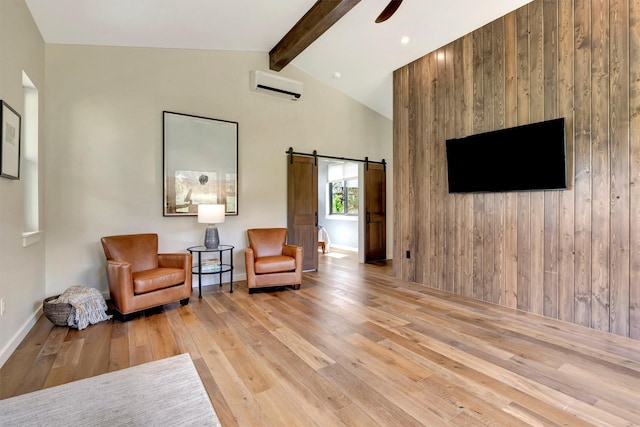 living area with hardwood / wood-style flooring, a barn door, an AC wall unit, baseboards, and vaulted ceiling with beams