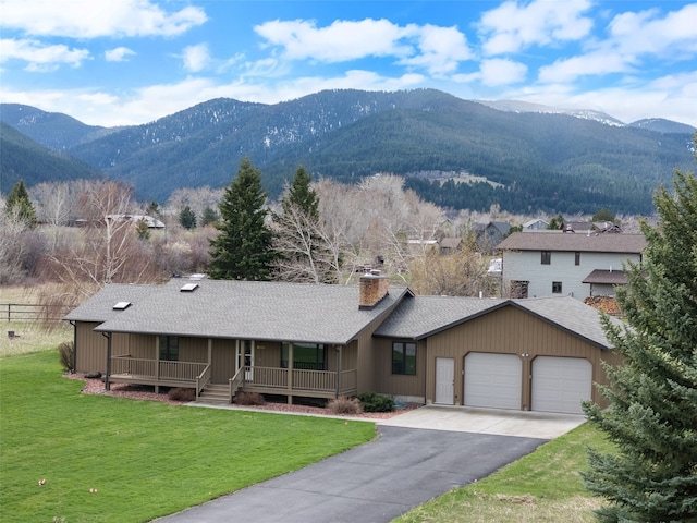 6280 Alamosa Ln, Bozeman, MT 59718 - view of front facade with covered porch, a mountain view, a garage, a chimney, and a shingled roof