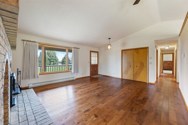 6280 Alamosa Ln, Bozeman, MT 59718 - unfurnished living room featuring a baseboard heating unit, hardwood / wood-style floors, a wood stove, and lofted ceiling