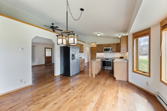 6280 Alamosa Ln, Bozeman, MT 59718 - kitchen featuring a baseboard heating unit, ceiling fan, a sink, brown cabinets, and appliances with stainless steel finishes