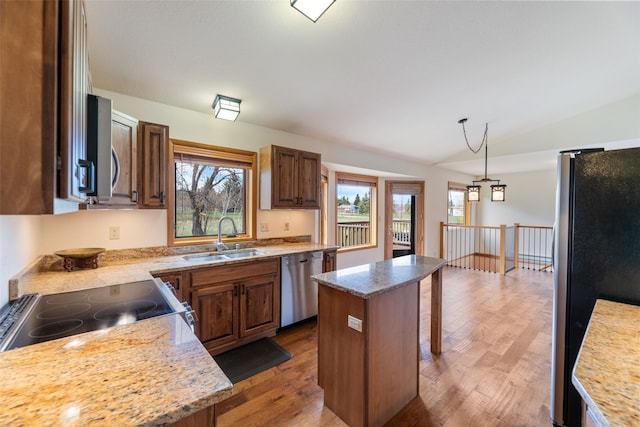 6280 Alamosa Ln, Bozeman, MT 59718 - kitchen featuring a sink, wood finished floors, a healthy amount of sunlight, and appliances with stainless steel finishes