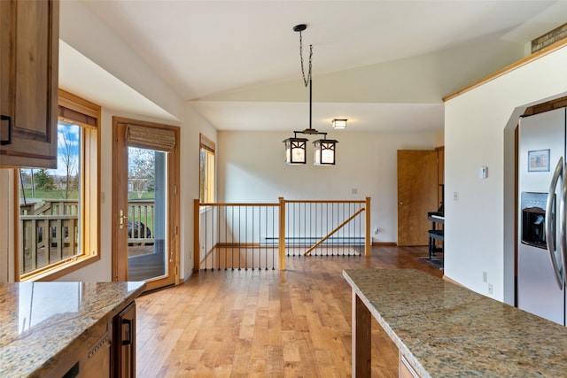 6280 Alamosa Ln, Bozeman, MT 59718 - unfurnished dining area with light wood finished floors, beverage cooler, vaulted ceiling, and arched walkways
