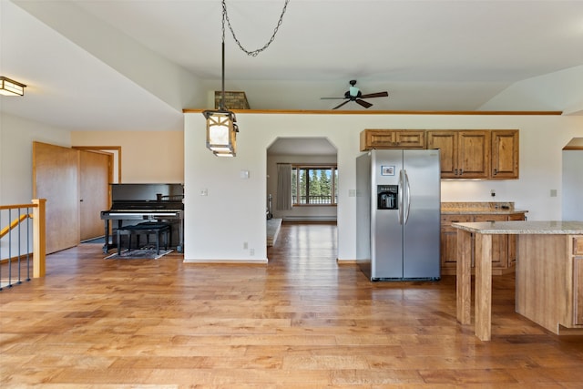 6280 Alamosa Ln, Bozeman, MT 59718 - kitchen featuring brown cabinets, light wood-style flooring, a ceiling fan, stainless steel refrigerator with ice dispenser, and arched walkways