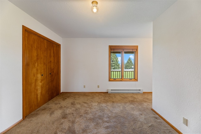 6280 Alamosa Ln, Bozeman, MT 59718 - unfurnished bedroom with a baseboard heating unit, baseboards, a closet, and carpet floors